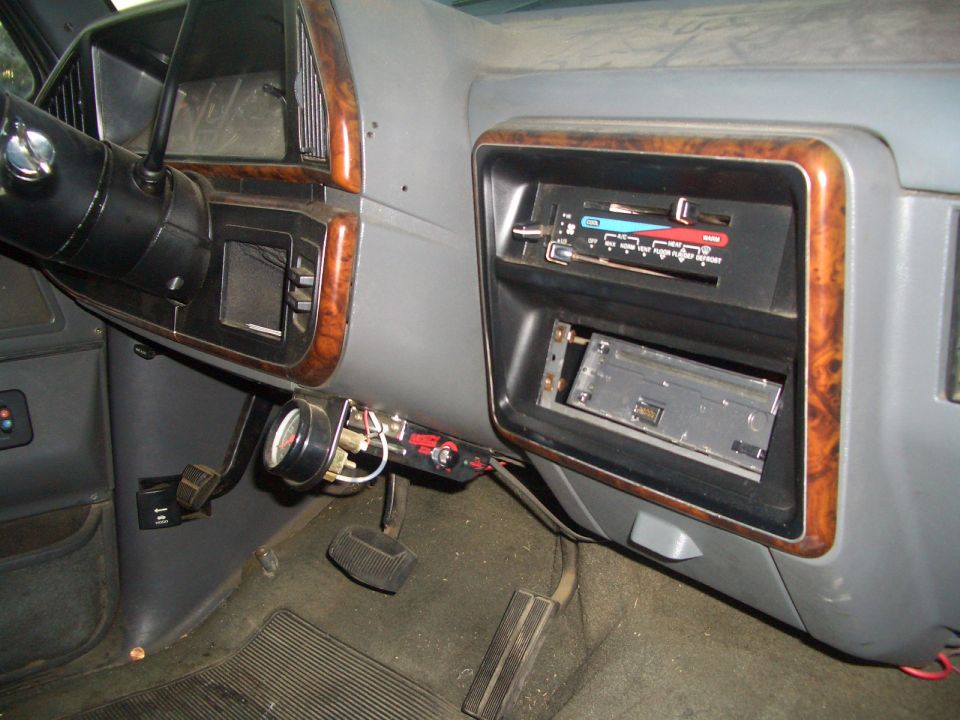 1988 Ford Bronco interior showing dashboard with aftermarket gauge and radio delete