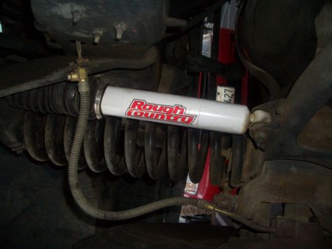 1988 Ford Bronco - Close-up view of a vehicle's suspension system, highlighting a Rough Country shock absorber and associated parts.