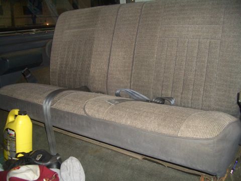 1988 Ford Bronco - Interior view of the rear bench seat in a 1988 Ford Bronco, with items on the floor.