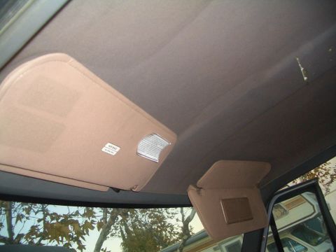 1988 Ford Bronco - The sun visors and headliner of a vehicle are visible, with a sticker indicating airbag presence.