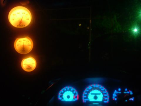 1993 Ford Taurus - Interior view of a car's dashboard at night, showing multiple illuminated gauges and digital displays.