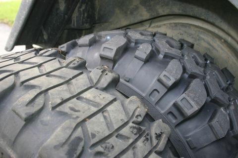 2003 Jeep TJ - Two off-road tires with deep, aggressive tread patterns are shown in a close-up view.