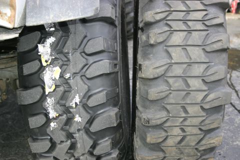 2003 Jeep TJ - Close-up view of two off-road tires, one showing debris.