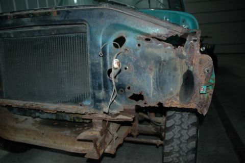 1963 Ford F-250 - Front end of a heavily rusted 1963 Ford F-250, showing extensive body damage and a teal paint job.