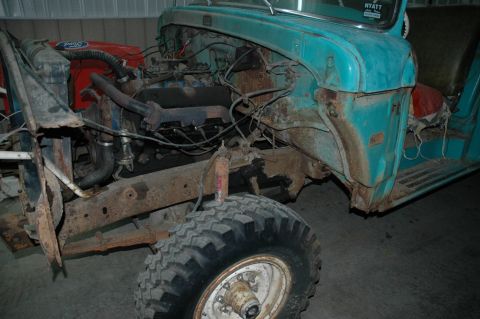 1963 Ford F-250 - Disassembled teal Ford truck with visible rust and engine components.