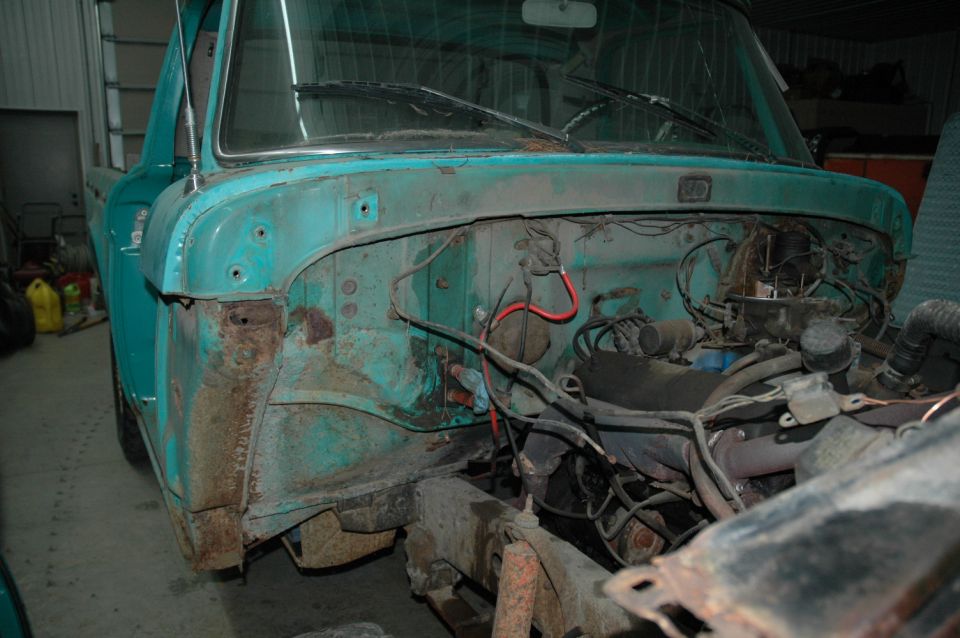 Teal 1961 Ford F-series truck engine bay with visible rust and engine components