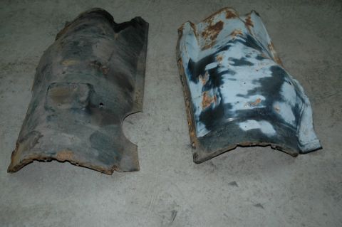 1963 Ford F-250 - Two old, corroded fender liners lie on a gray concrete surface.