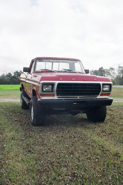 1979 Ford F-150 - Front view of a red 1979 Ford F-150 pickup truck on a grassy field.