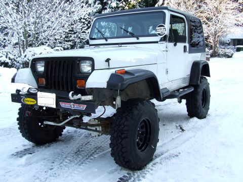 1991 Jeep Wrangler - This 1991 Jeep Wrangler is equipped with Hella lights and a black soft top, seen here on a snowy day.