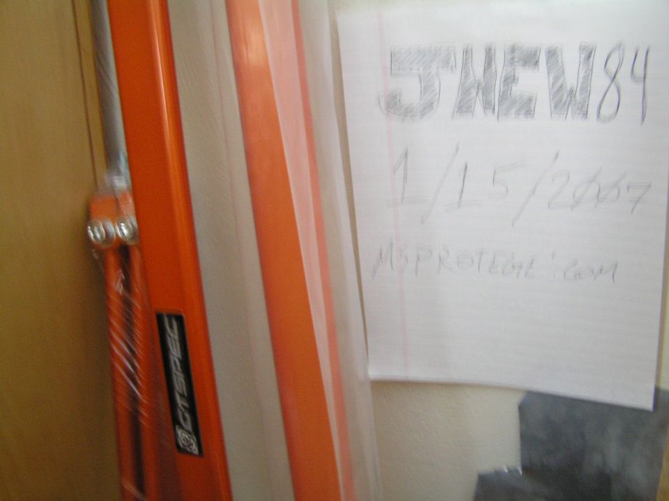 Orange and white striped object with a label reading "CTSPEC" and a handwritten note with "JHEW84 1/15/2007 MOPROTEGE.COM"