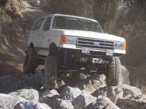 1991 Ford Bronco - This 1991 Ford Bronco is navigating a challenging rocky terrain on an off-road trail.