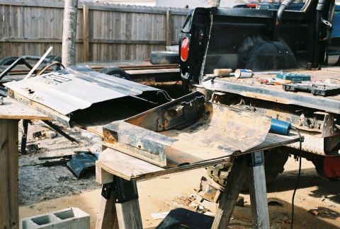 1978 Ford Bronco - The rear of a pickup truck bed and its detached tailgate are shown, with various tools scattered on the bed's surface.