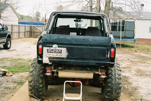 1978 Ford Bronco - Rear view of a modified 1978 Ford Bronco with large off-road tires and a "Don't Follow Me" sticker.