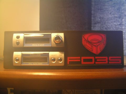 1993 Mazda RX-7 - Panel with Mazda rotary emblem, FD3S text, and two car stereos.