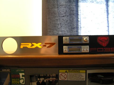 1993 Mazda RX-7 - A close-up of car emblems and audio equipment, including RX-7 and FD3S branding.