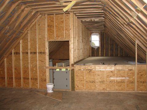 1992 Ford Bronco - An unfinished attic space shows exposed framing, a small window, and a garage door, suggesting potential for conversion.