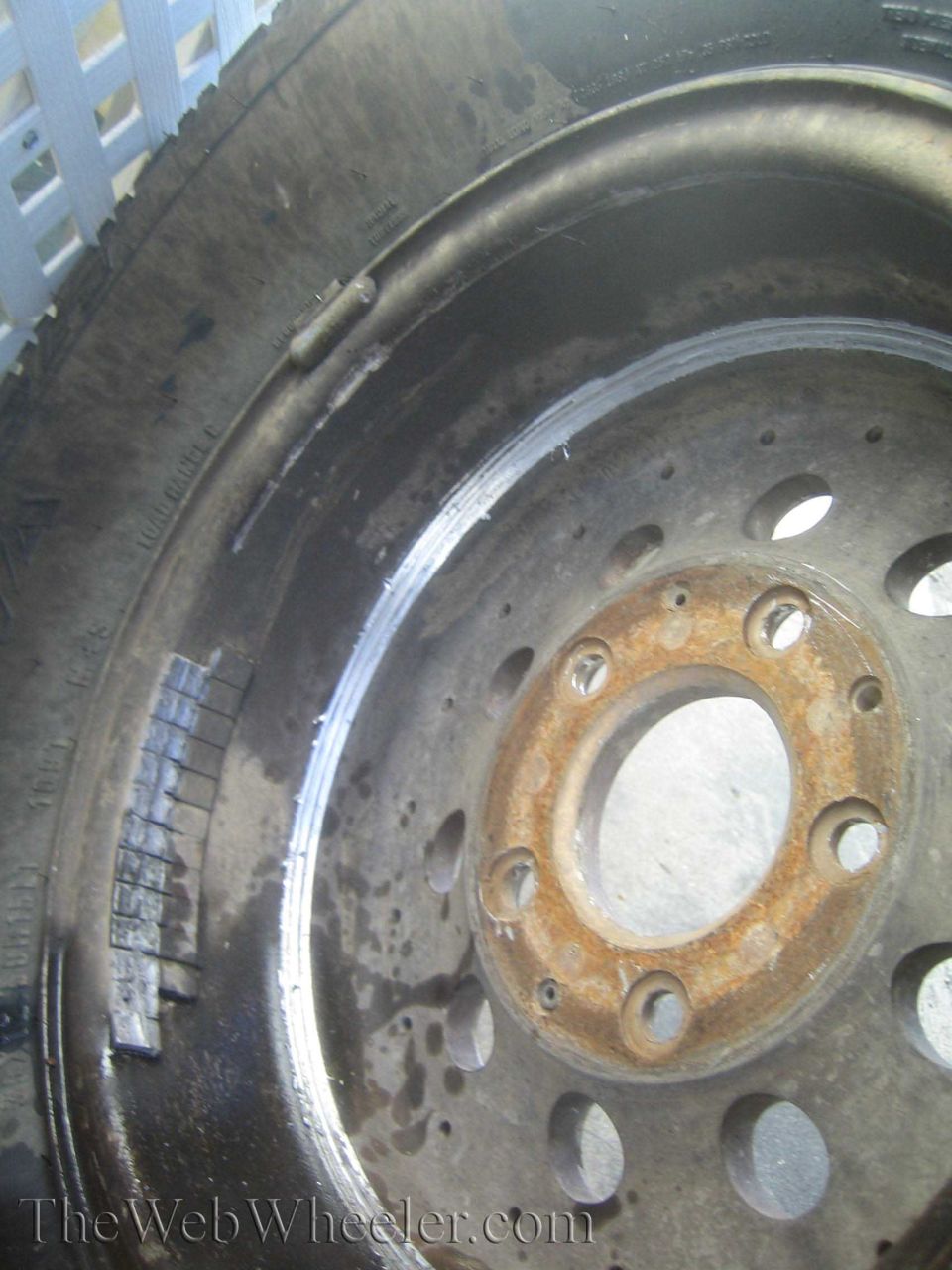 Close-up of a steel wheel rim and brake drum with a rusted hub center