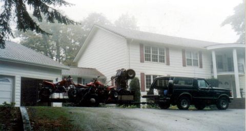 1991 Ford Bronco - A black 1991 Ford Bronco is parked in front of a house, towing a trailer loaded with ATVs.