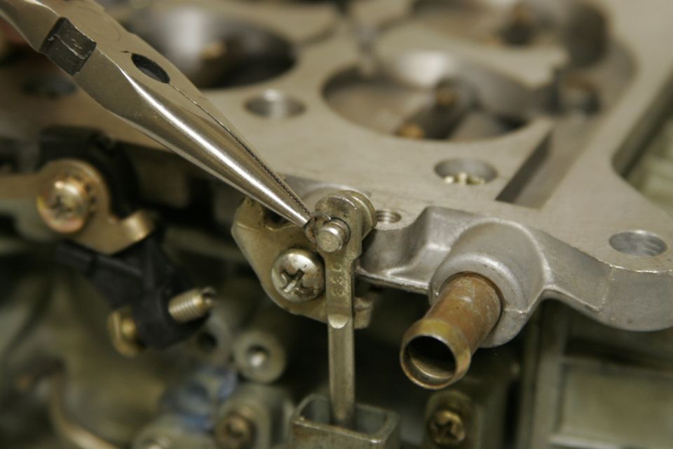 To remove the vacuum secondary, first remove the c-clip attaching the connecting rod to the secondary throttle shaft.