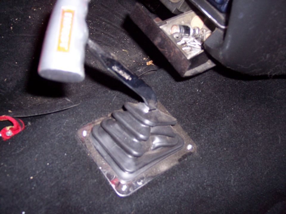 Black rubber floor shifter boot and lever in a carpeted vehicle interior.