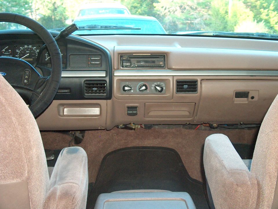 Interior shot of a 1992 Ford Bronco, showing the dashboard, steering wheel, and seats