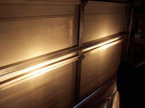 1995 Ford Probe - The headlights of a vehicle are illuminated in front of a closed garage door.