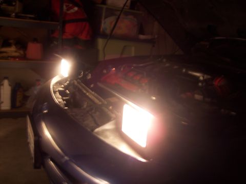 1995 Ford Probe - A car's headlight is on, illuminating the engine bay and front fender area.