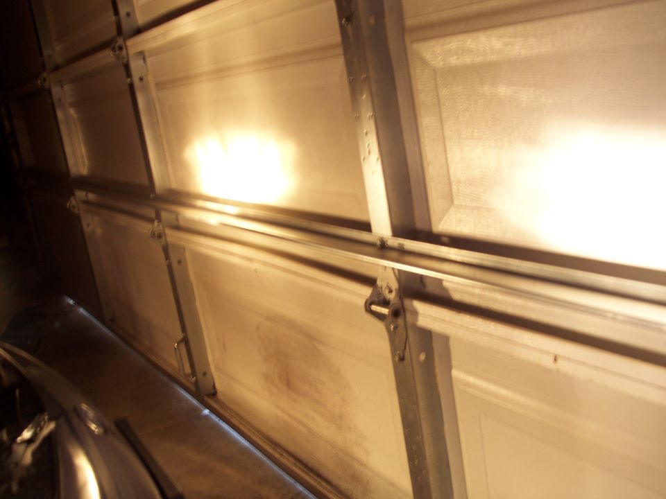 Overhead garage door with lights reflecting off the panels