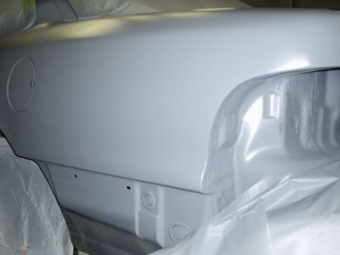 1996 Ford Crown Victoria - The rear quarter panel of a vehicle is shown covered in gray primer, indicating it is in the process of being refinished.