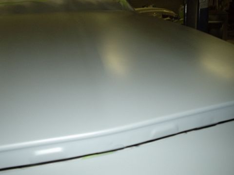 1996 Ford Crown Victoria - Close-up of a car hood with primer, indicating preparation for refinishing.