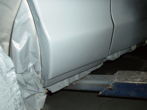 1996 Ford Crown Victoria - Detail of a vehicle's side panel and rocker, undergoing preparation for refinishing.