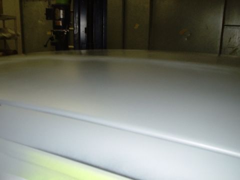 1996 Ford Crown Victoria - The image shows a car roof, possibly undergoing refinishing, with a reflection of machinery in the background.