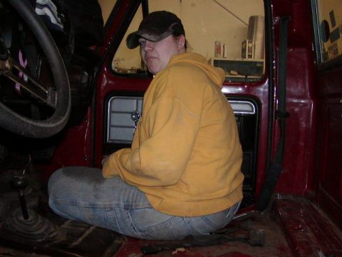 1979 Ford F-150 - A person sits on the floor of a truck's interior, looking towards the camera.