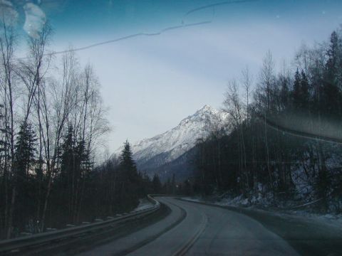 1979 Ford F-150 - Driving on a winter road with trees and a mountain visible.