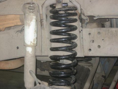 1979 Ford F-150 - A detailed view of the suspension system, showing a coil spring and shock absorber.