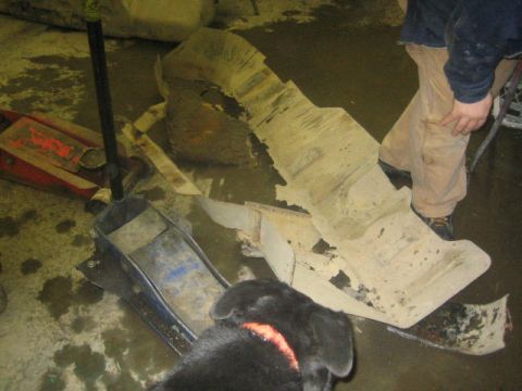 1979 Ford F-150 - A person is standing near a large, damaged car part that has been removed from a vehicle.