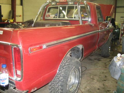 1979 Ford F-150 - Side view of a red 1979 Ford F-150 pickup truck parked in a workshop.