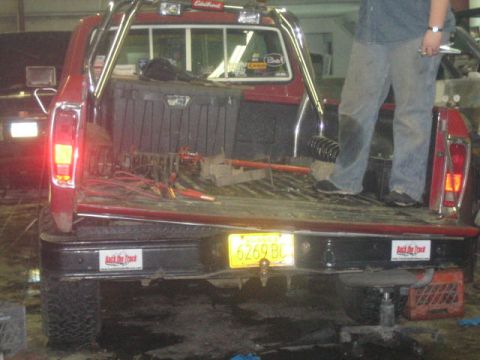 1979 Ford F-150 - Rear view of a red 1979 Ford F-150 pickup truck with a toolbox and various items in the bed.