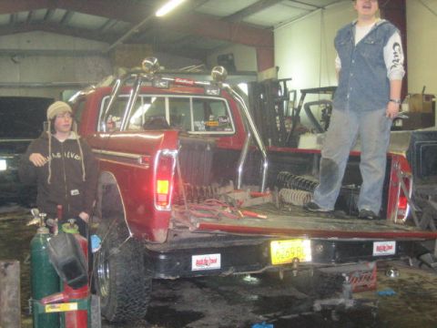 1979 Ford F-150 - A red 1979 Ford F-150 pickup truck is parked inside a garage with two people nearby.