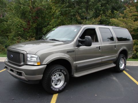 2002 Ford Excursion - This Ford Excursion SUV is seen from a three-quarter front angle, with a tan exterior and trees in the background.