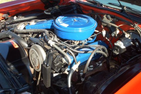 1974 Ford Ranchero - Engine bay of a 1974 Ford Ranchero, a blue air cleaner assembly and orange body panels.