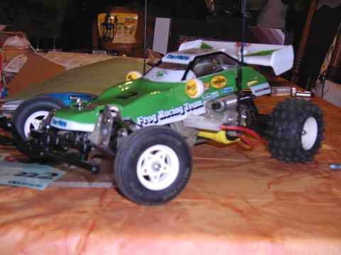 1993 Ford Bronco - A green remote control car with racing decals sits on a wooden surface.