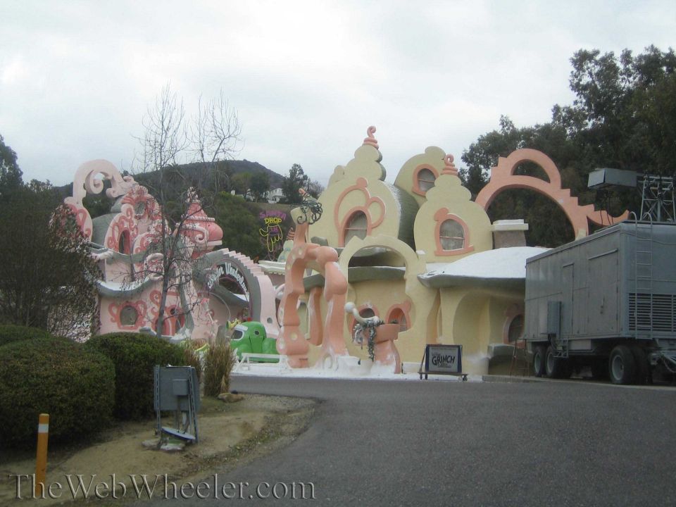 Whimsical pink and tan Whoville-style buildings beside a road and trailer