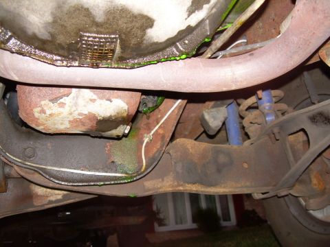 1988 Ford Bronco - Green fluid is leaking from the transmission pan onto the exhaust system and frame of the vehicle.