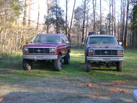 1989 Ford Bronco - Two Ford Broncos, likely from the early 1980s, are parked outdoors on a grassy area.