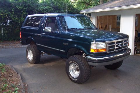 1994 Ford Bronco - This lifted Ford Bronco is parked in front of a garage.