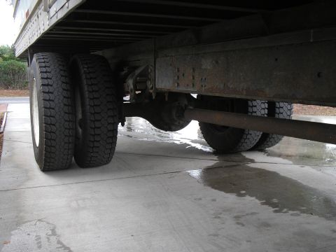 1999 Ford F-800 - Close-up view of the rear dual wheels and the undercarriage of a large truck.