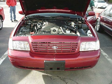 2002 Ford Crown Victoria - Front view of a 2002 Ford Crown Victoria, hood up, revealing the engine compartment.