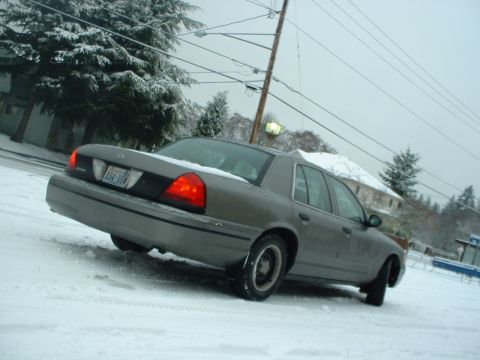 2000 Ford Crown Victoria - A gray 2000 Ford Crown Victoria is seen from the rear 3/4 angle on a snowy day.
