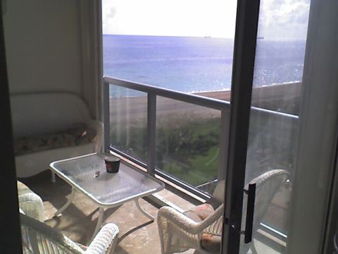 1984 BMW 3 Series - A view from a balcony shows wicker furniture and a glass table with the ocean and beach in the background.
